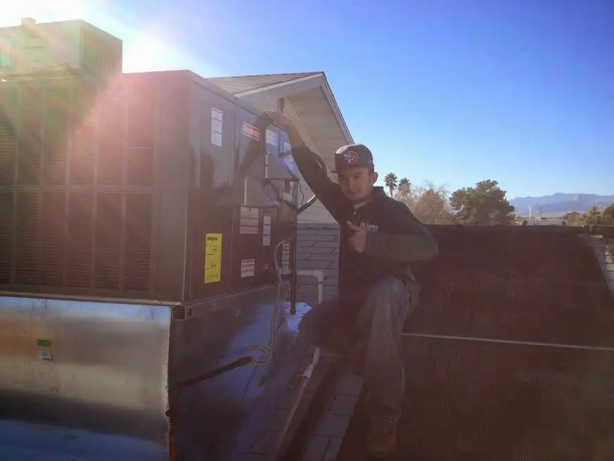 HVAC technician performing Air Duct Cleaning on a rooftop unit in Whitewater
