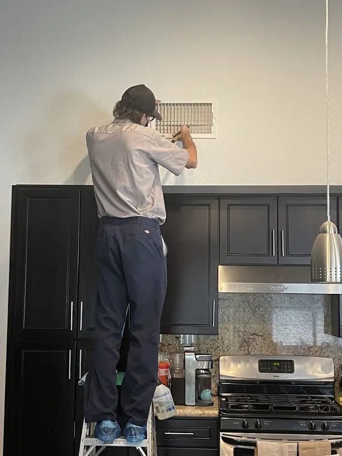 Technician inspecting an air vent during HVAC service in Whitewater